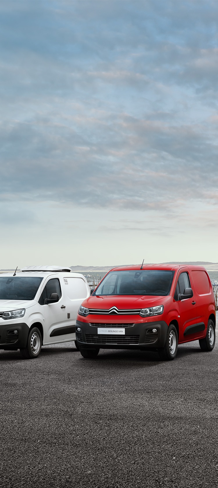 Citroën C3 Rouge avec coucher de soleil et ville en fond
